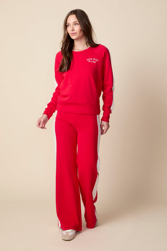 Woman wearing a red tracksuit with a logo on a beige background