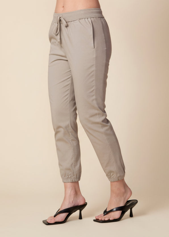 Beige pants worn by a person on a beige background