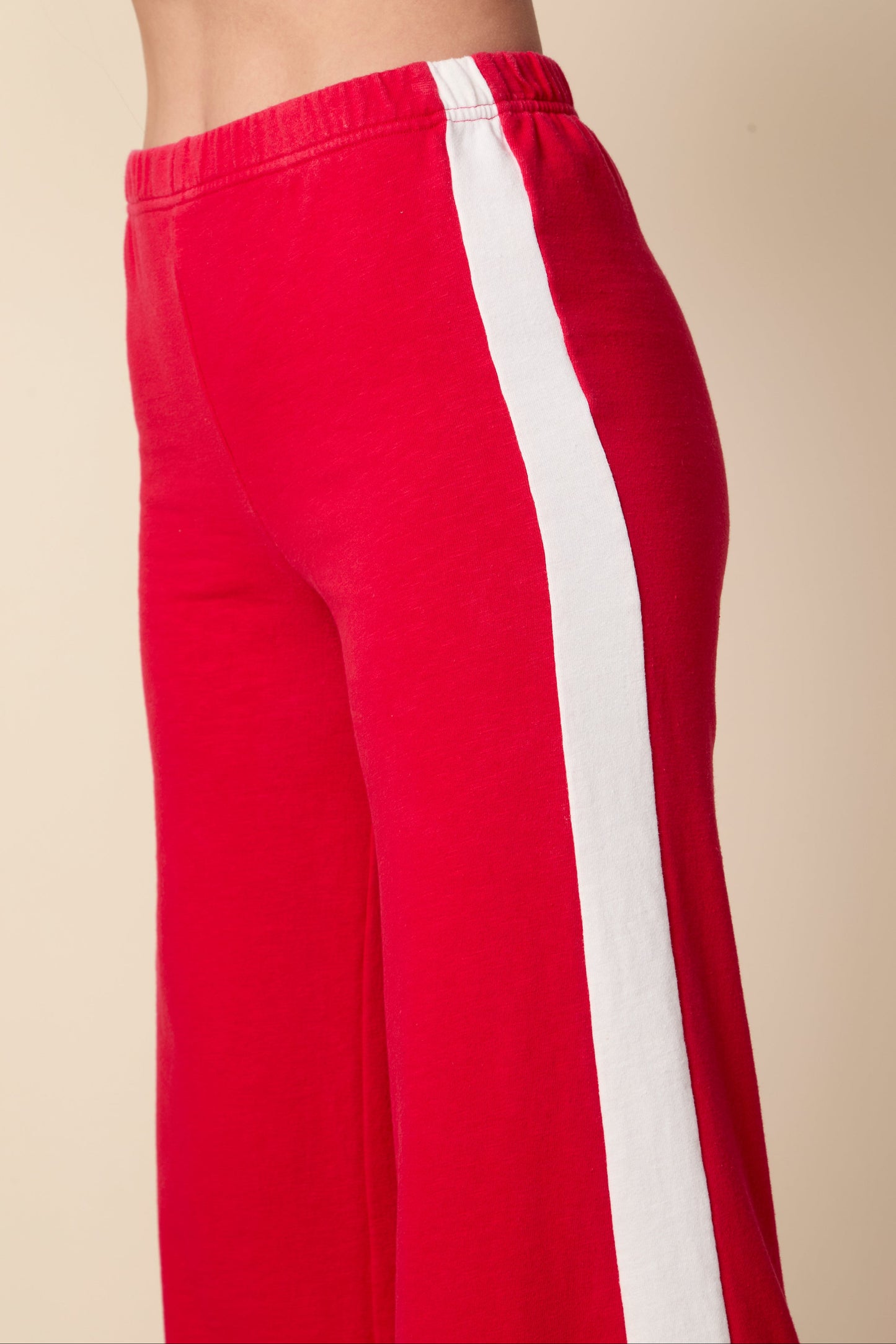 Red pants with a white stripe on a beige background