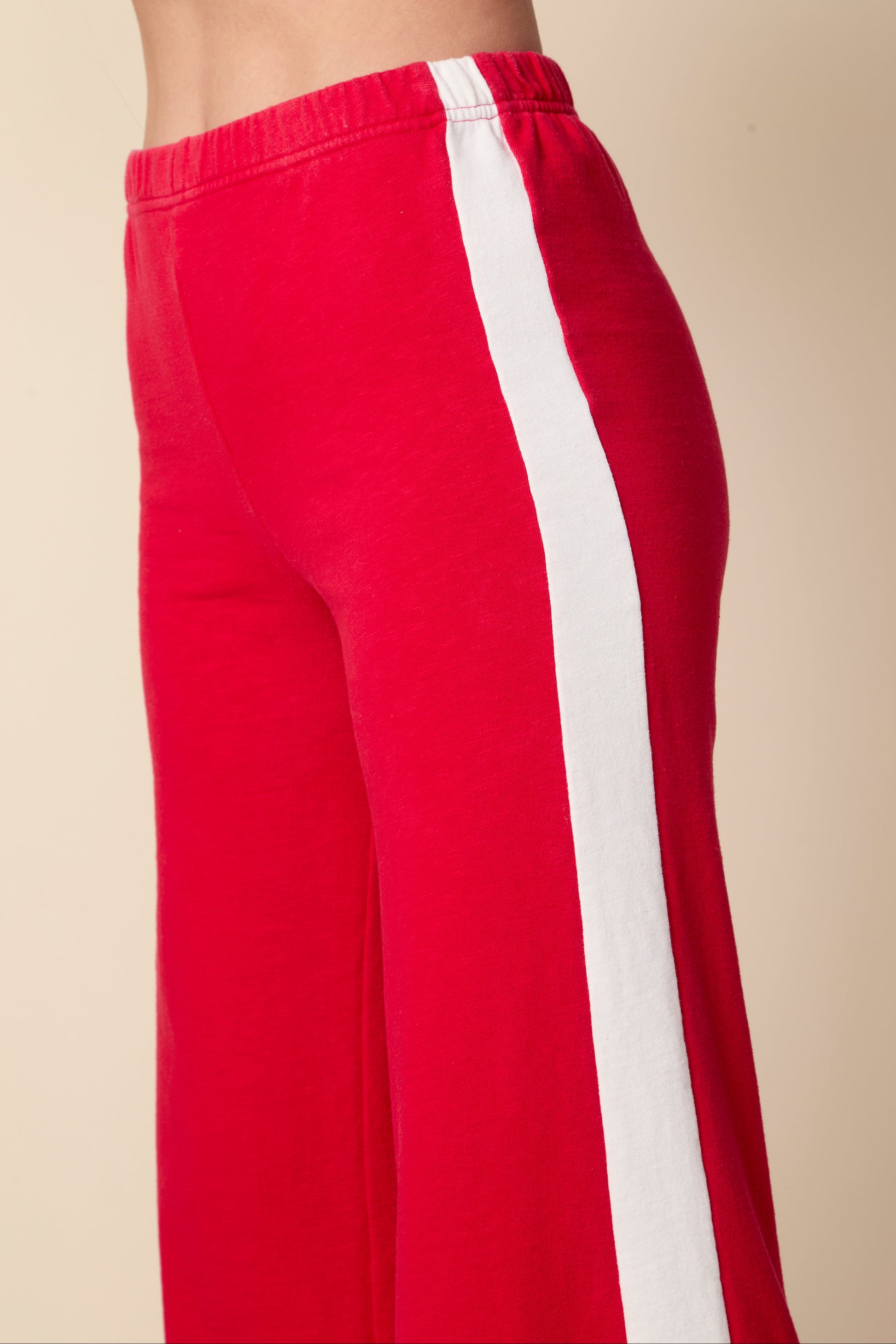 Red pants with a white stripe on a beige background